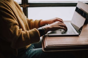 Person working on laptop, image from a side angle