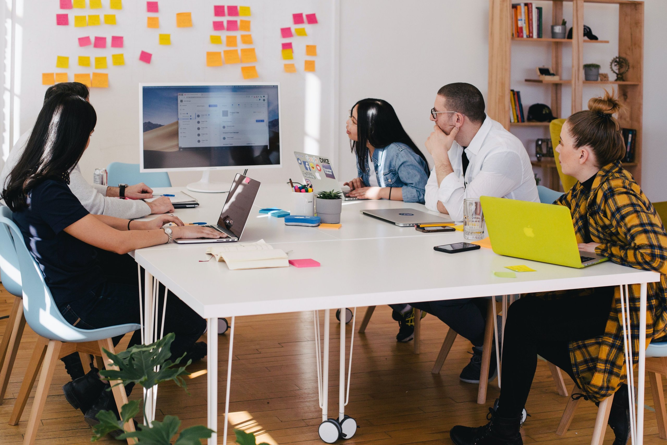 Team using sticky notes on the whiteboard, discussing how best to integrate Amazon Sponsored Products into their marketing campaign.